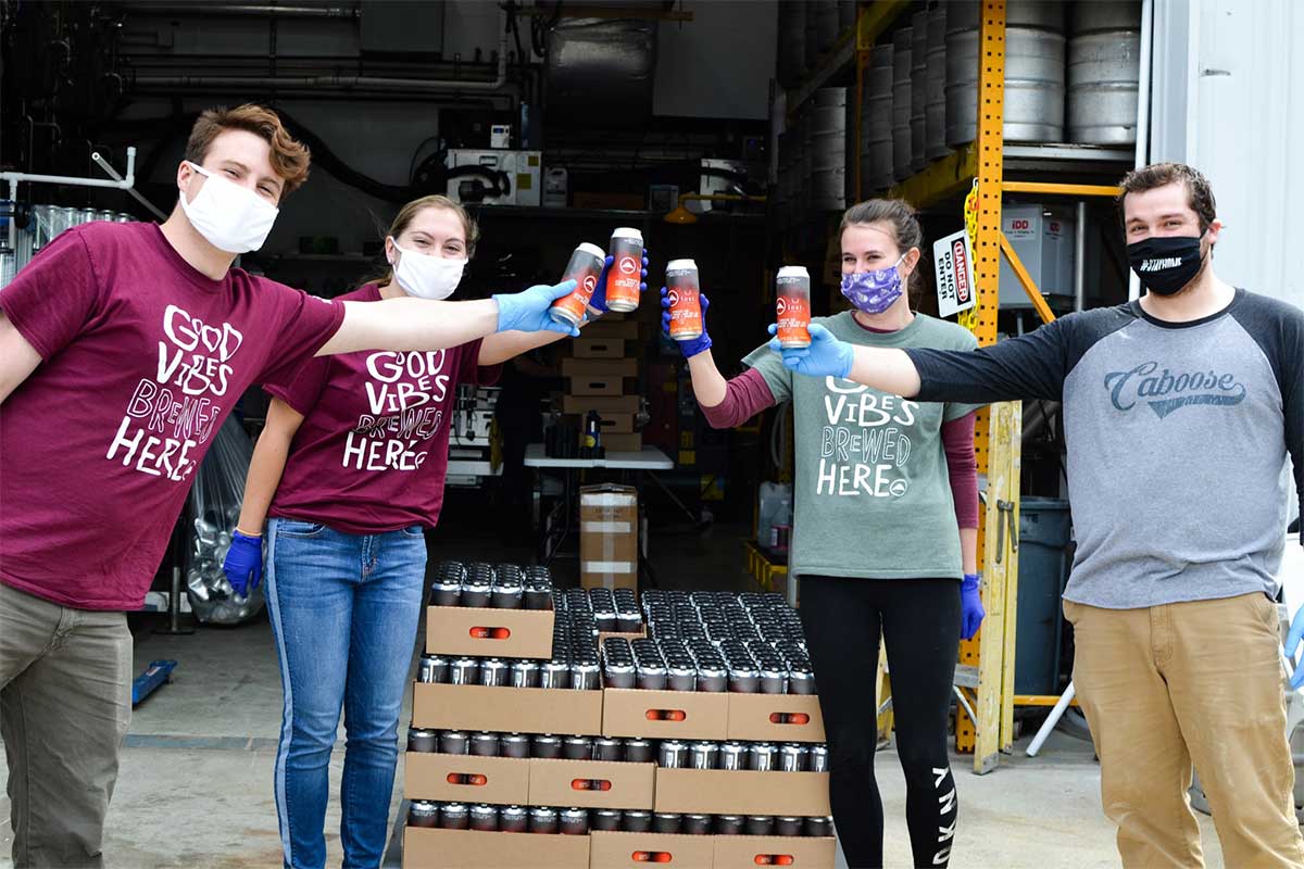 caboose brewing staff with masks and beer cans