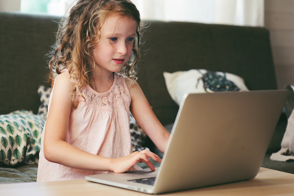 child using laptop at home. School girl learning with computer indoor.