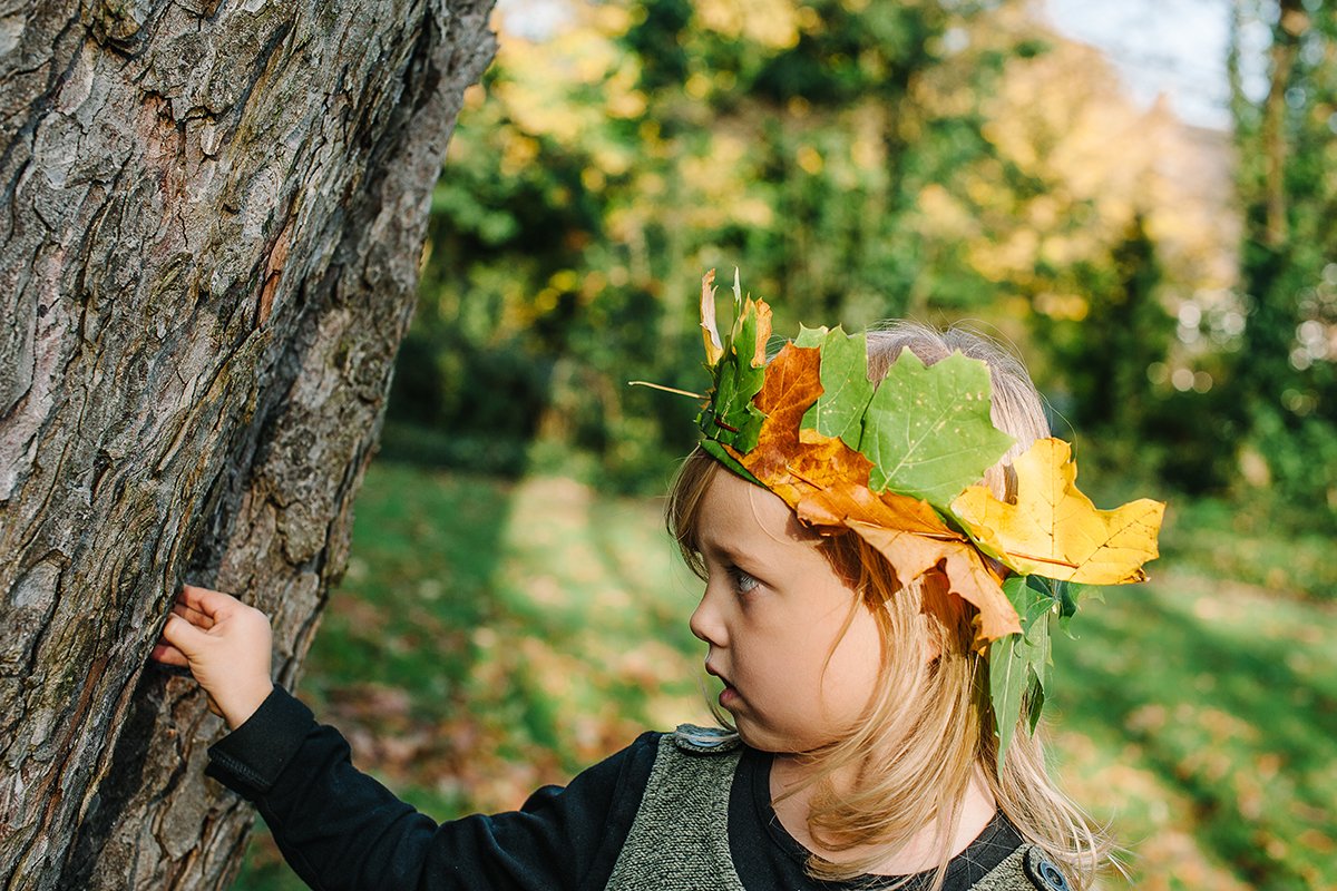 Portrait of young child with leaf crown, autumn concept