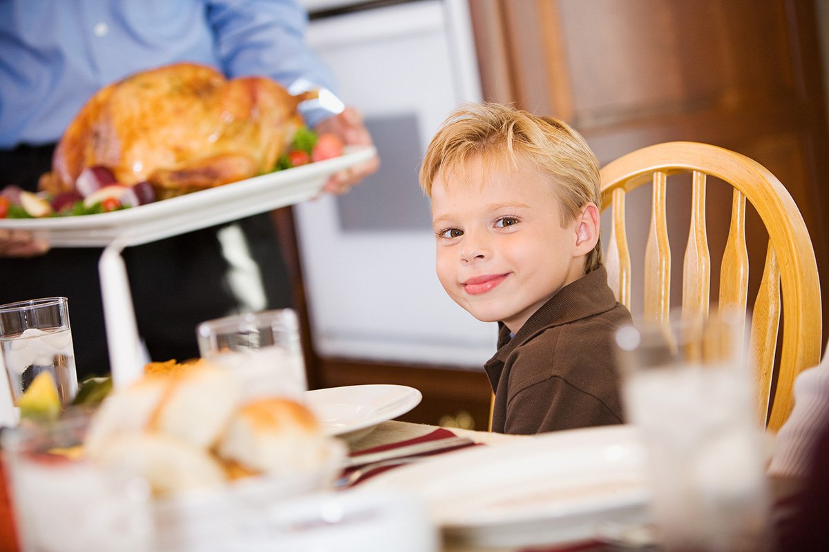 Thanksgiving: Smiling Boy Waits As Turkey Is Brought To Table