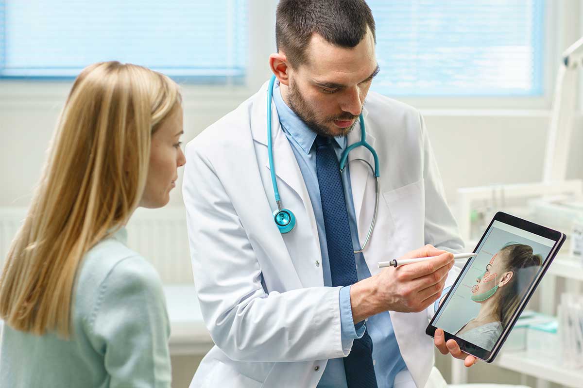doctor with patient showing her image of face on ipad