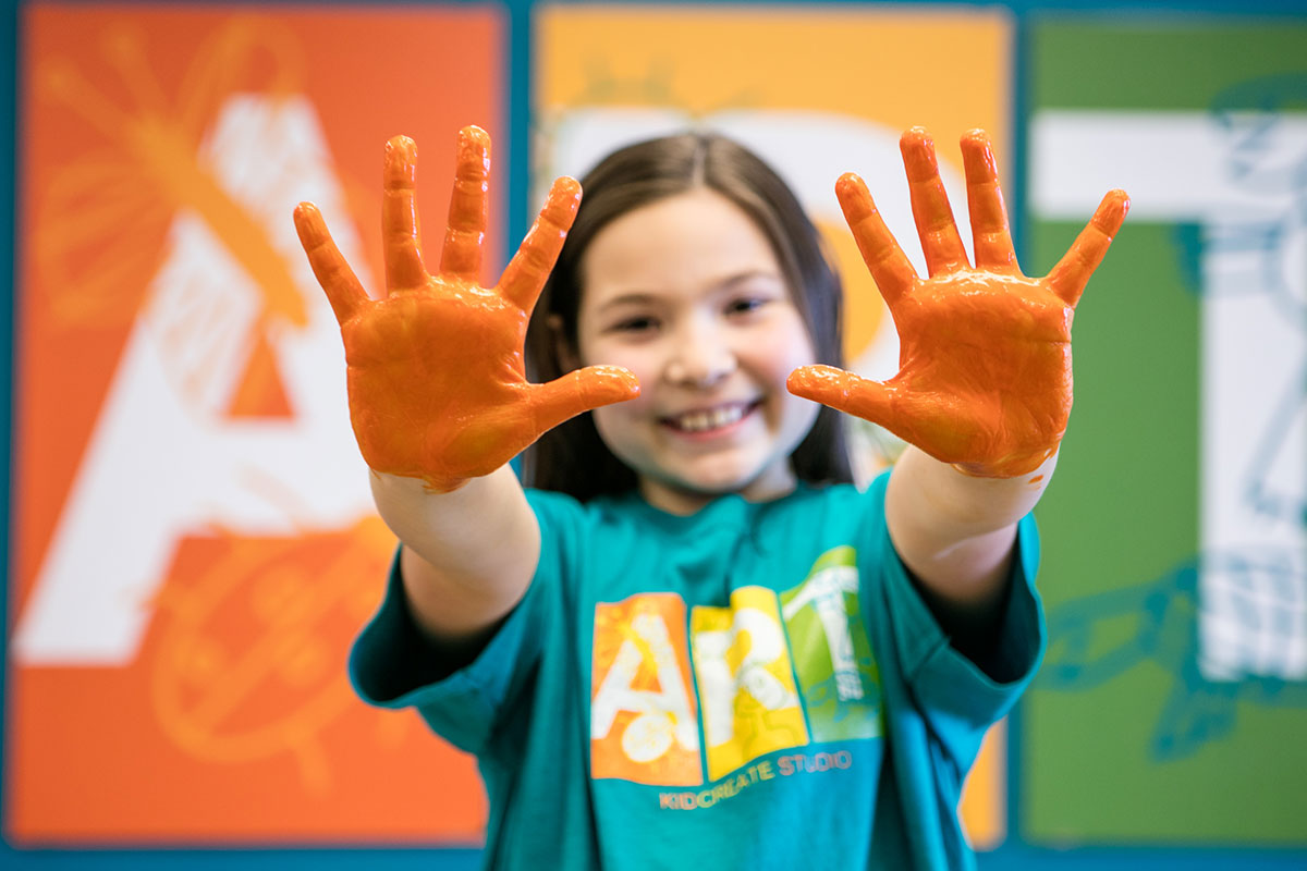 girl with orange paint on hands