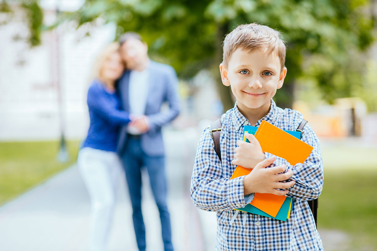 boy smiling with books in hand