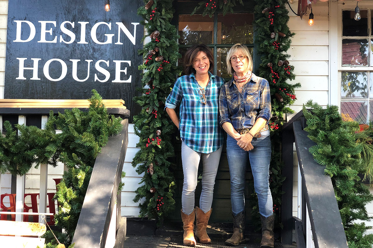 two women in plaid in front of design house