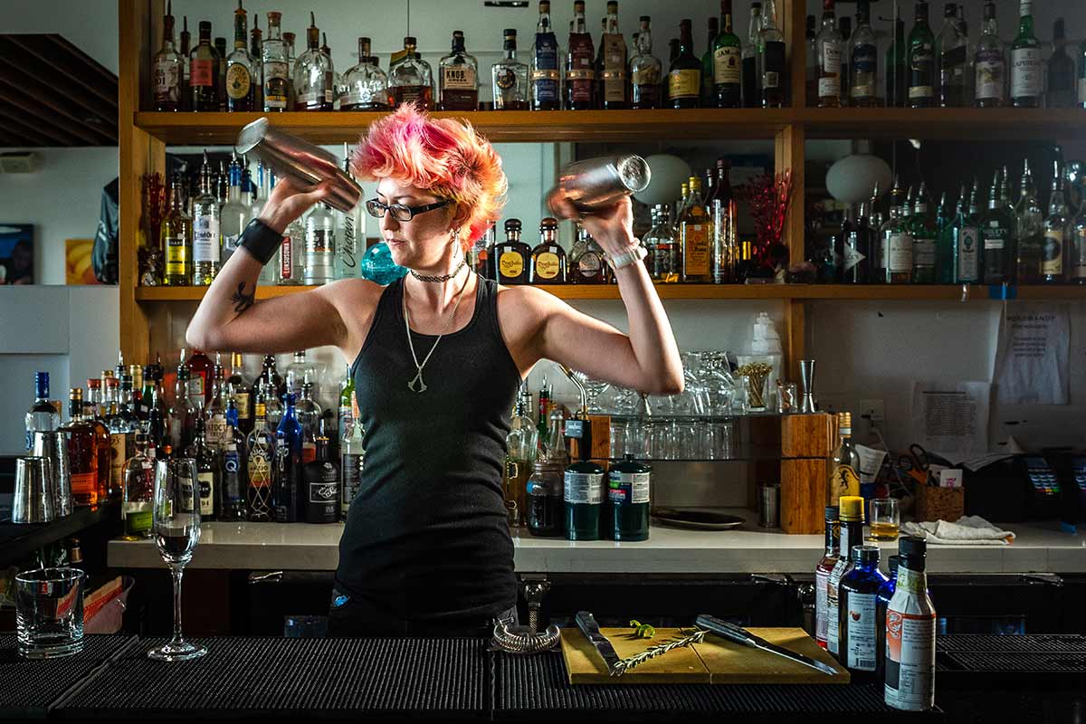 bartender with pink hair shaking drinks