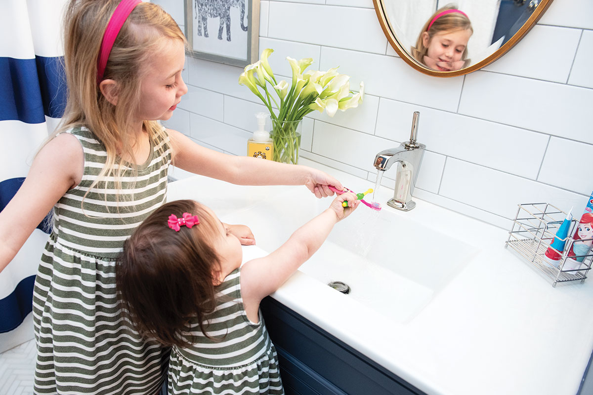 children rinsing toothbrush in sink