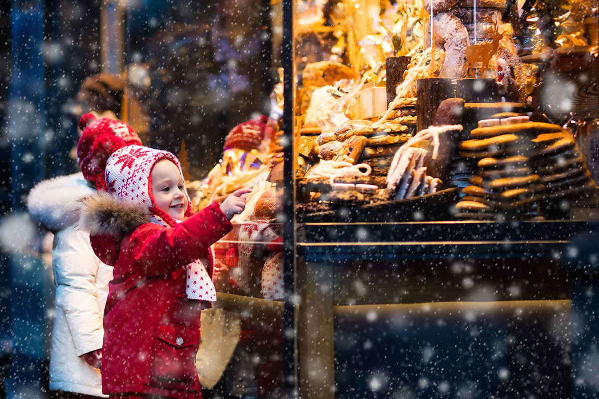 children looking at holiday storefront window