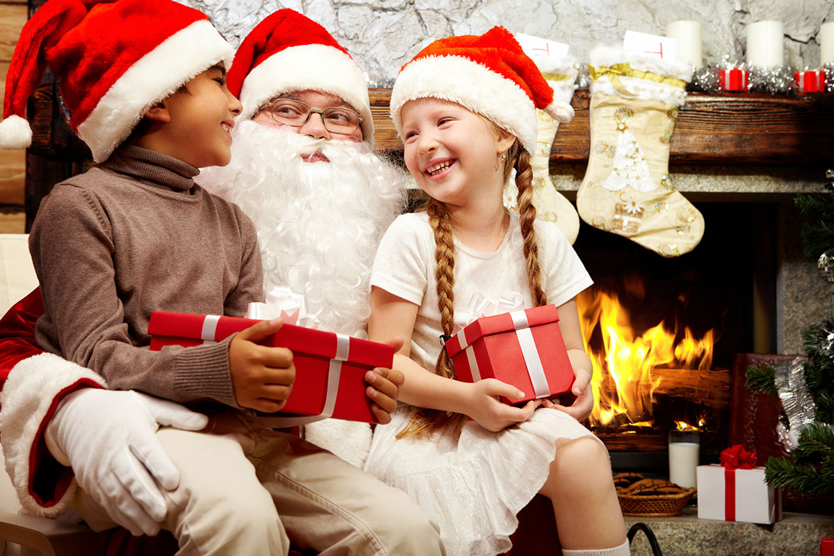 santa with kids on lap by fire