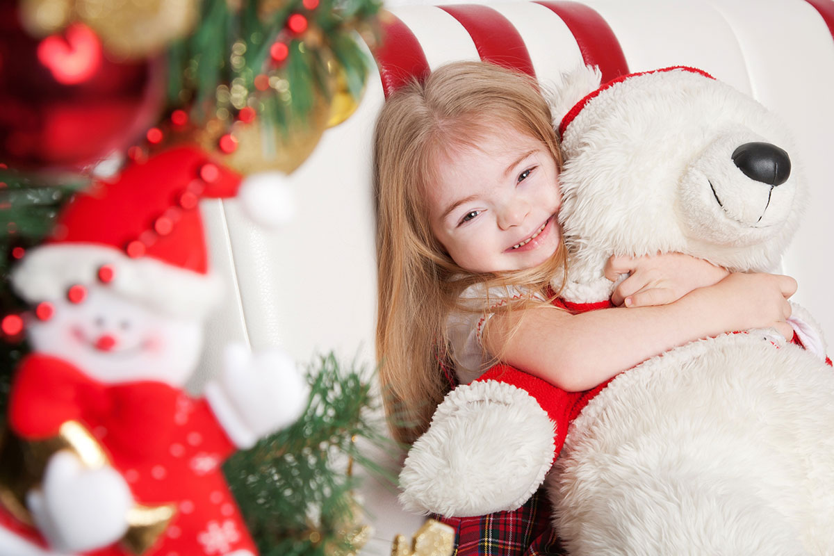 small blonde girl holding teddy bear
