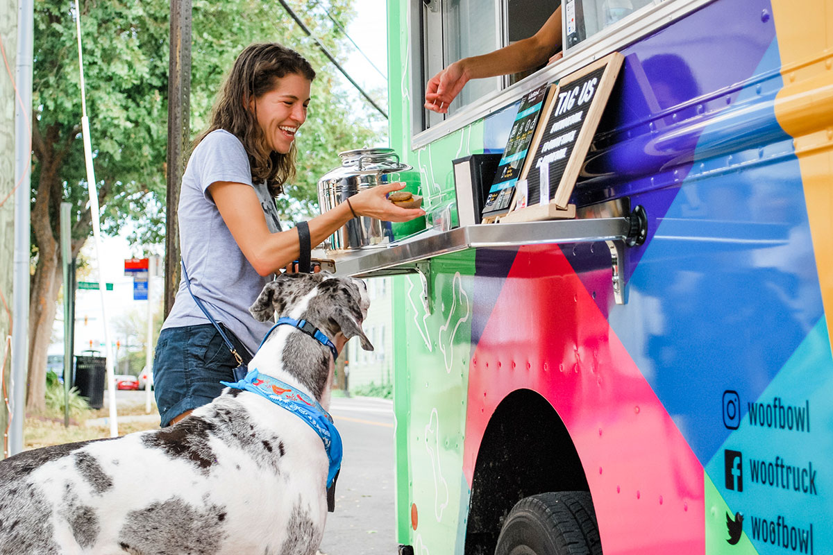 woman with dog paying for her meal at dog food truck
