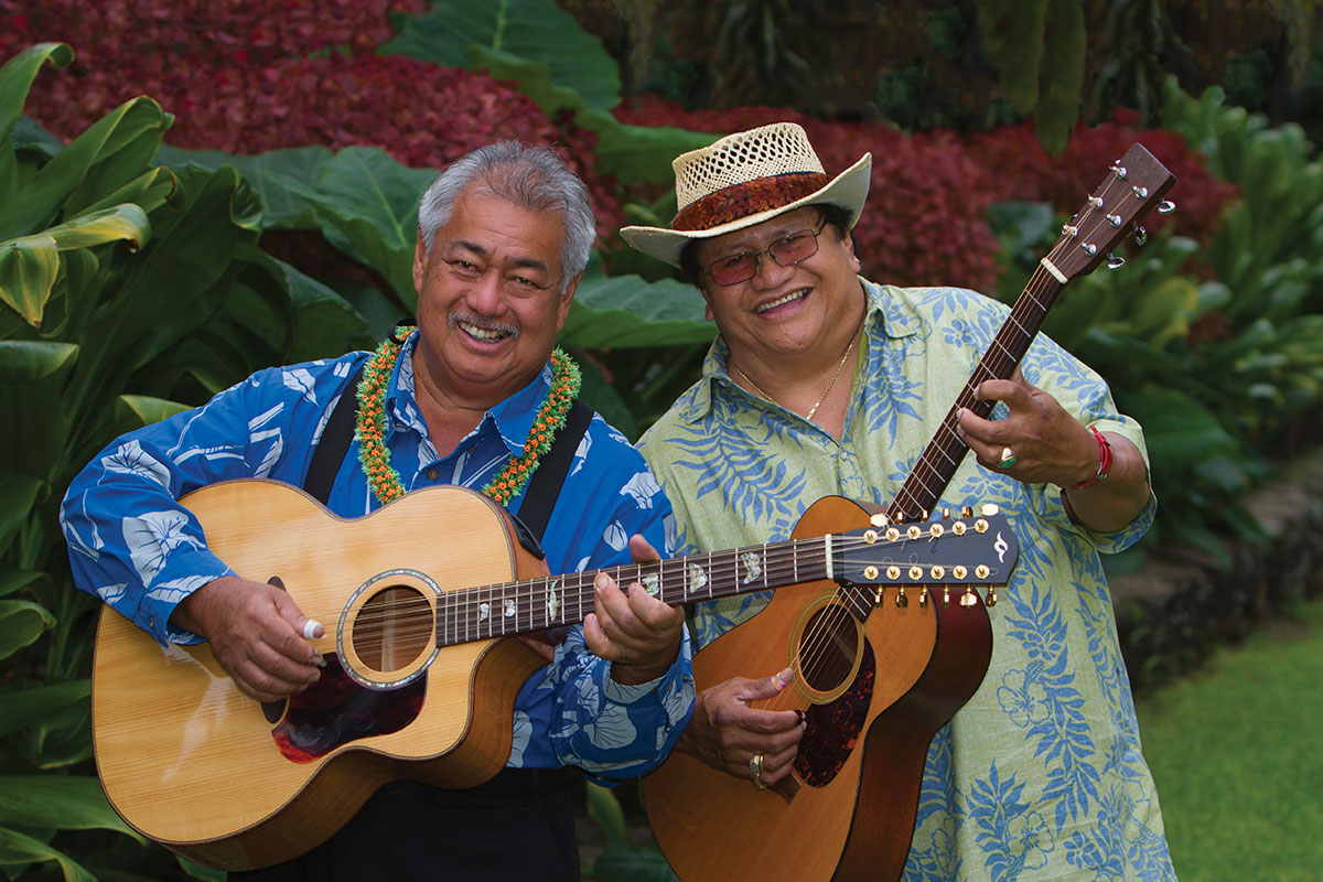two men in Hawaiian shirts with guitars