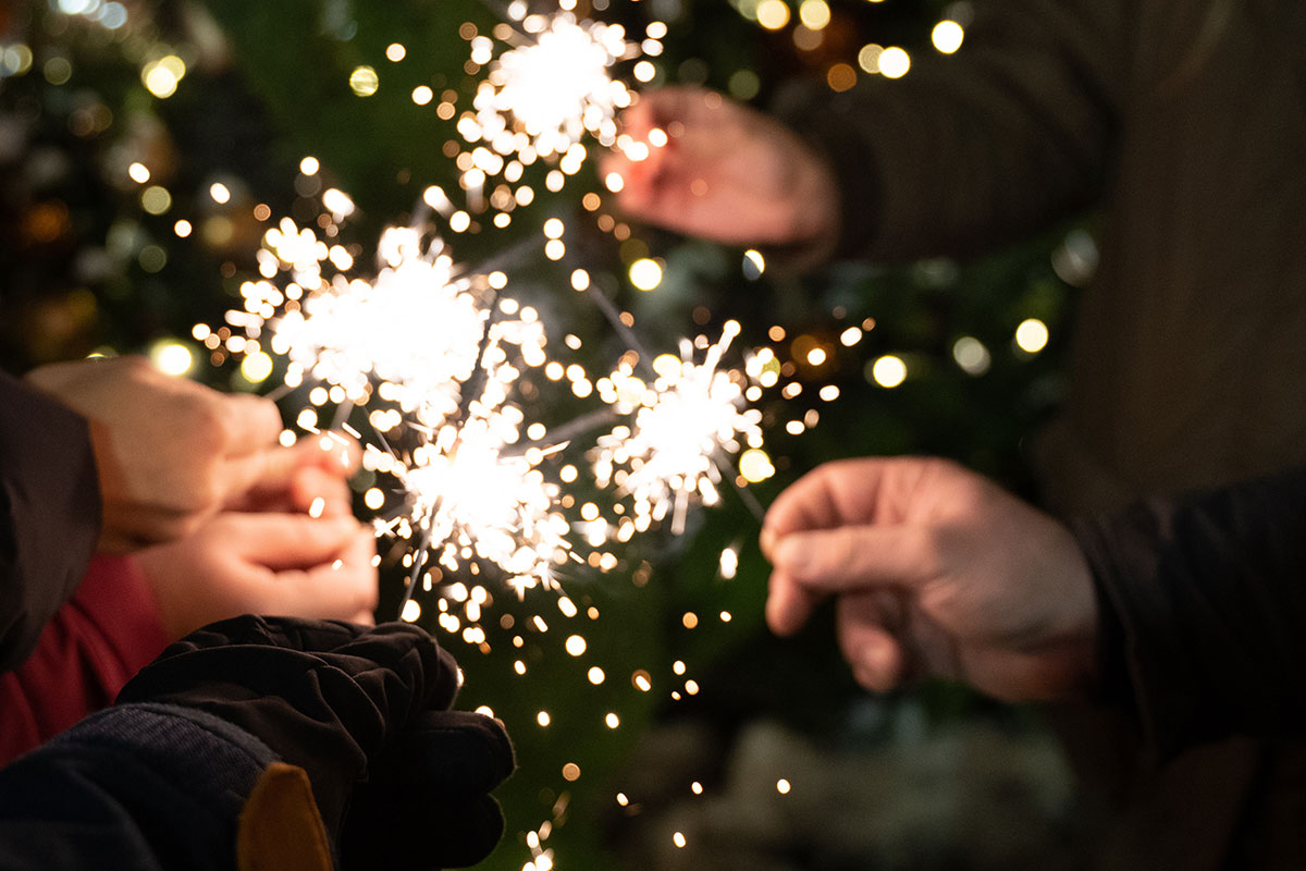 people holding sparklers on new year's eve