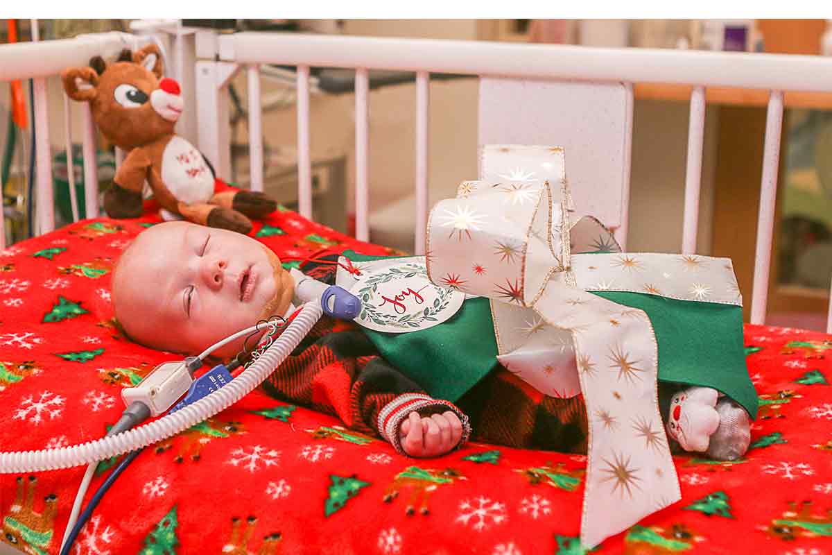 a baby at the nicu wrapped as a present for a holiday photoshoot
