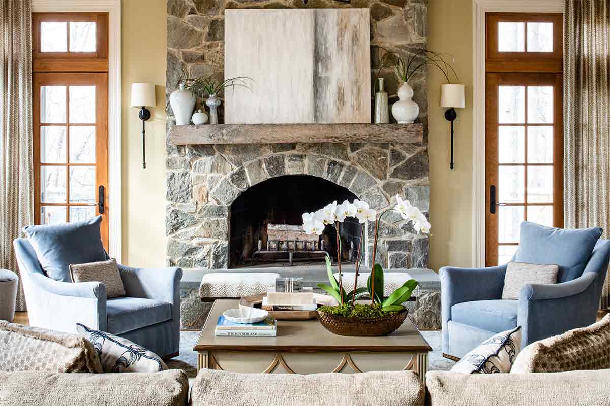 blue chairs in front of stone fireplace
