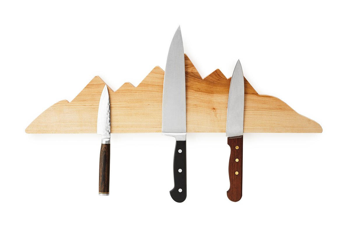 three knives on brown mountain holder