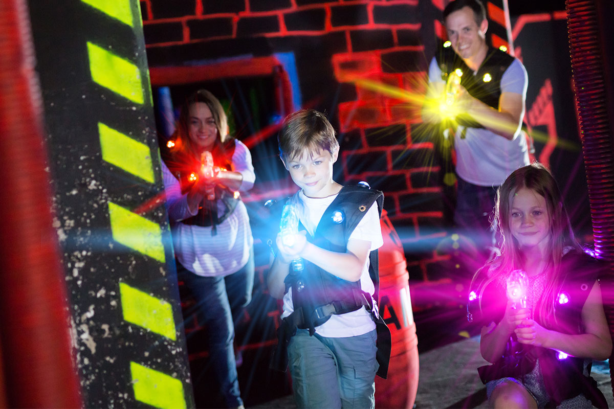 kids playing laser tag with red, blue, pink and yellow lasers
