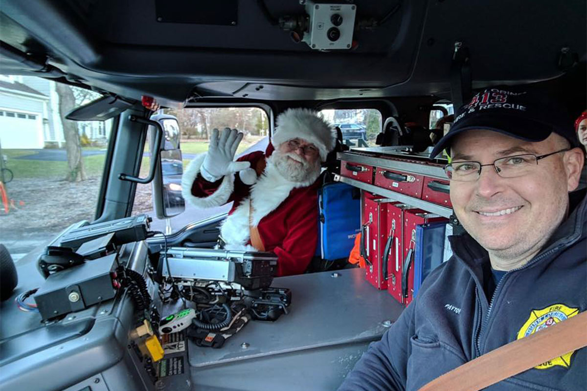 santa claus with firefighter in truck
