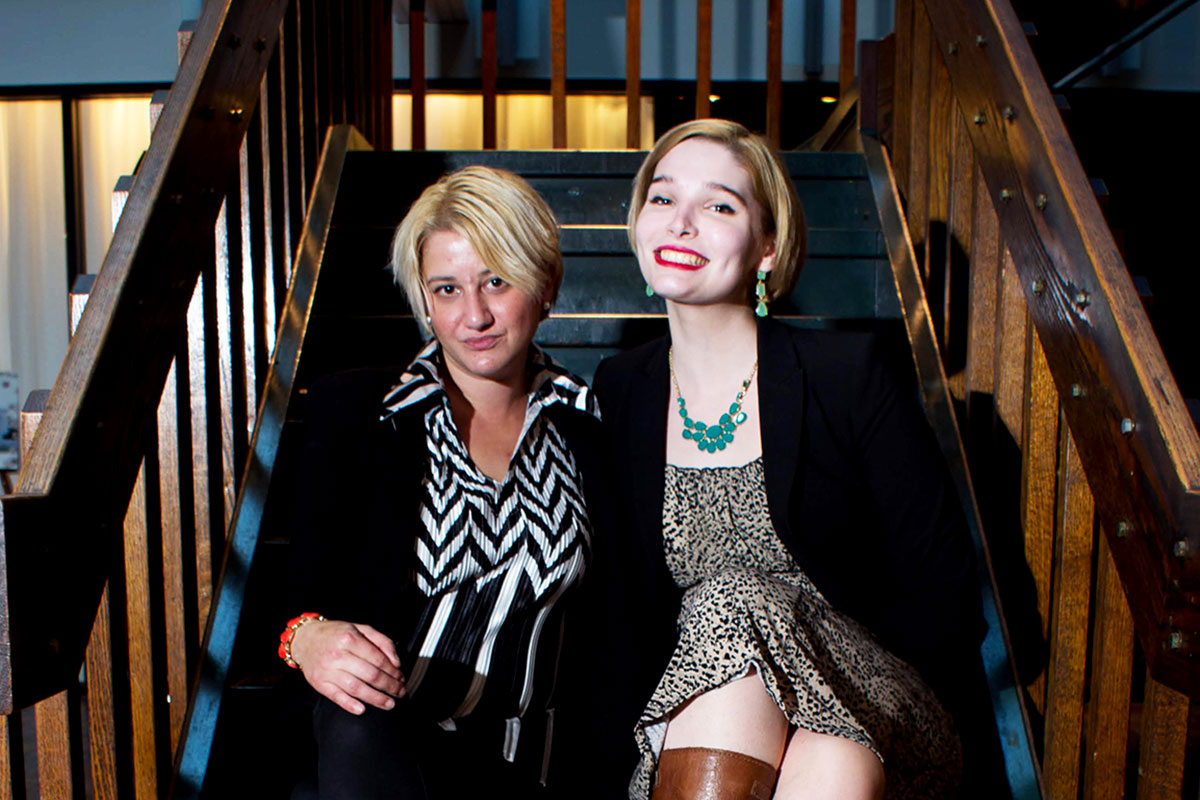 two women with short hair on brown stairs