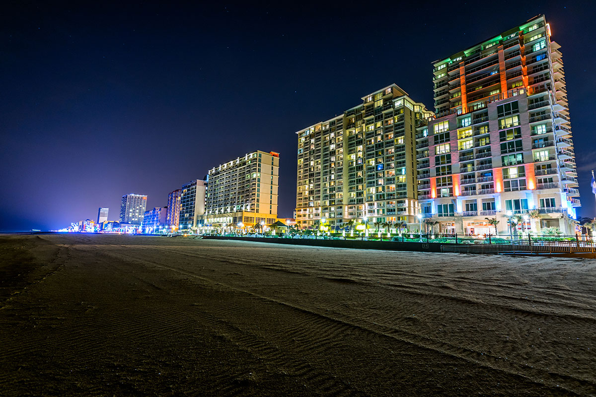 hotels alongside the beach lit up at nighttime
