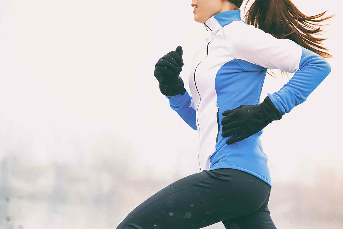 woman running in cold weather with gloves and fleece sweatshirt on