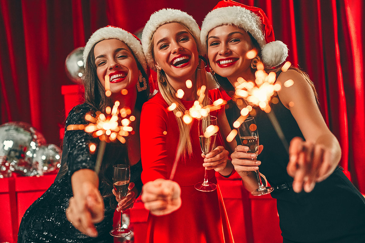 three women with Santa hats and sparklers