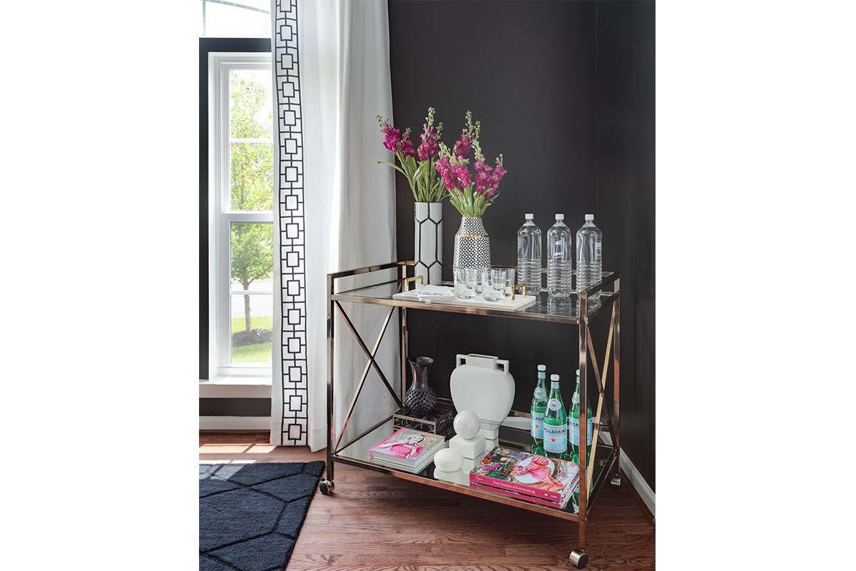 bar cart with pink flowers and books and water bottles