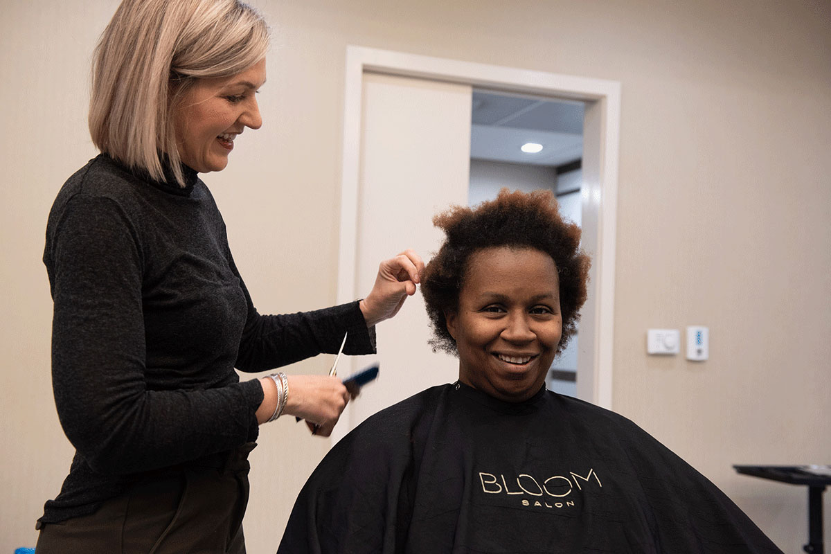 woman cutting an african american woman's hair