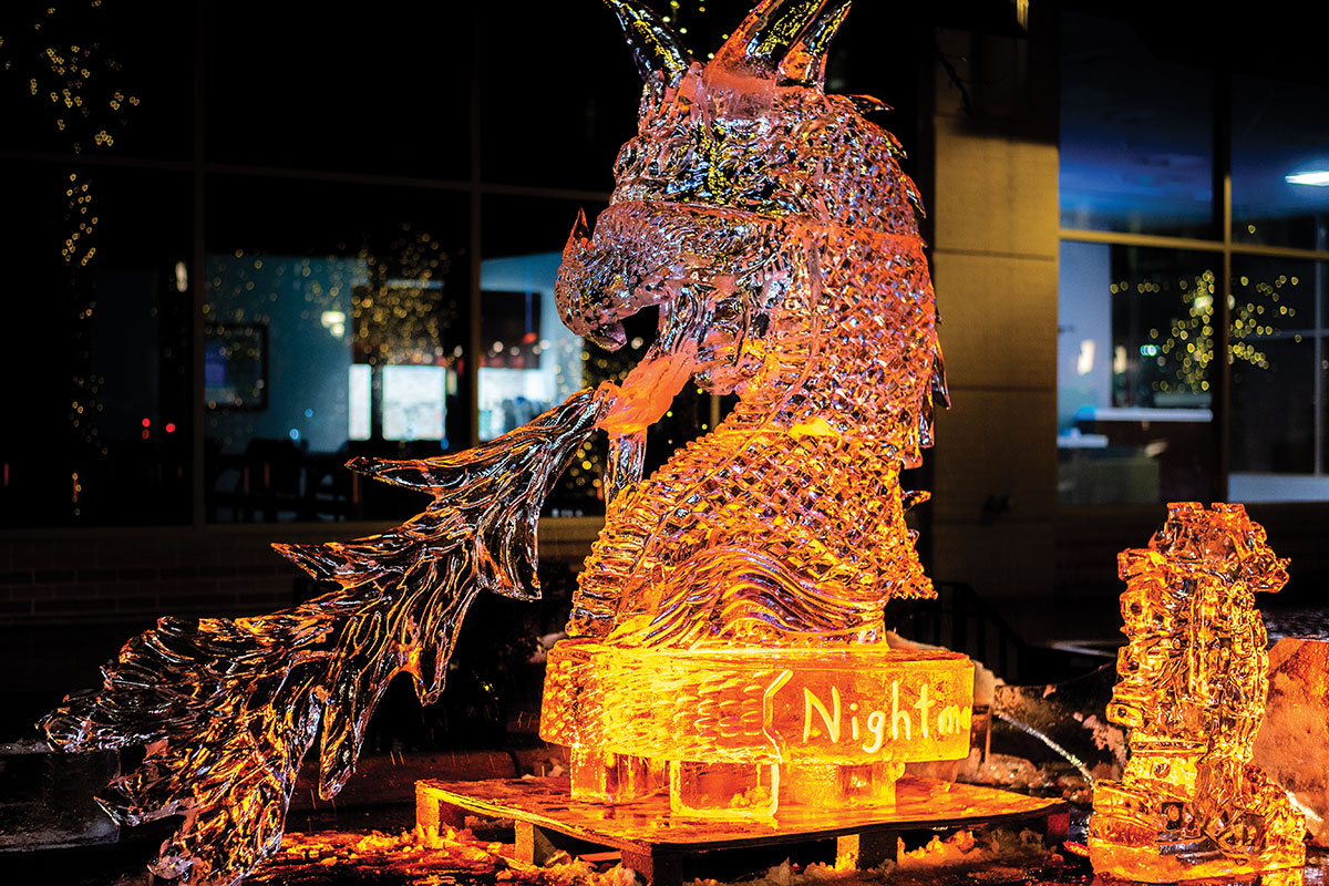 large dragon carved from ice with orange lights
