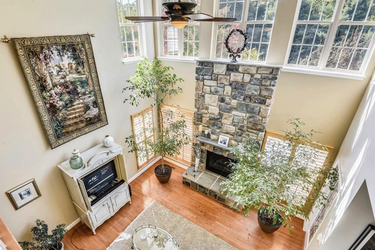 living room with high ceilings and stone fireplace
