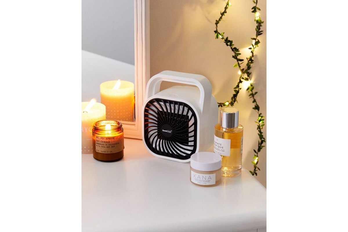 portable heater on white desk with candles around it