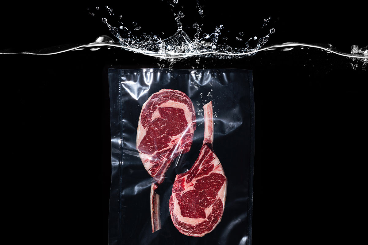 two pieces of steak in plastic bag in water