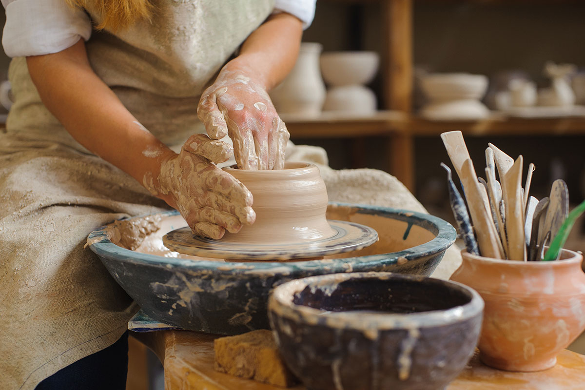 woman spinning pottery on wheel