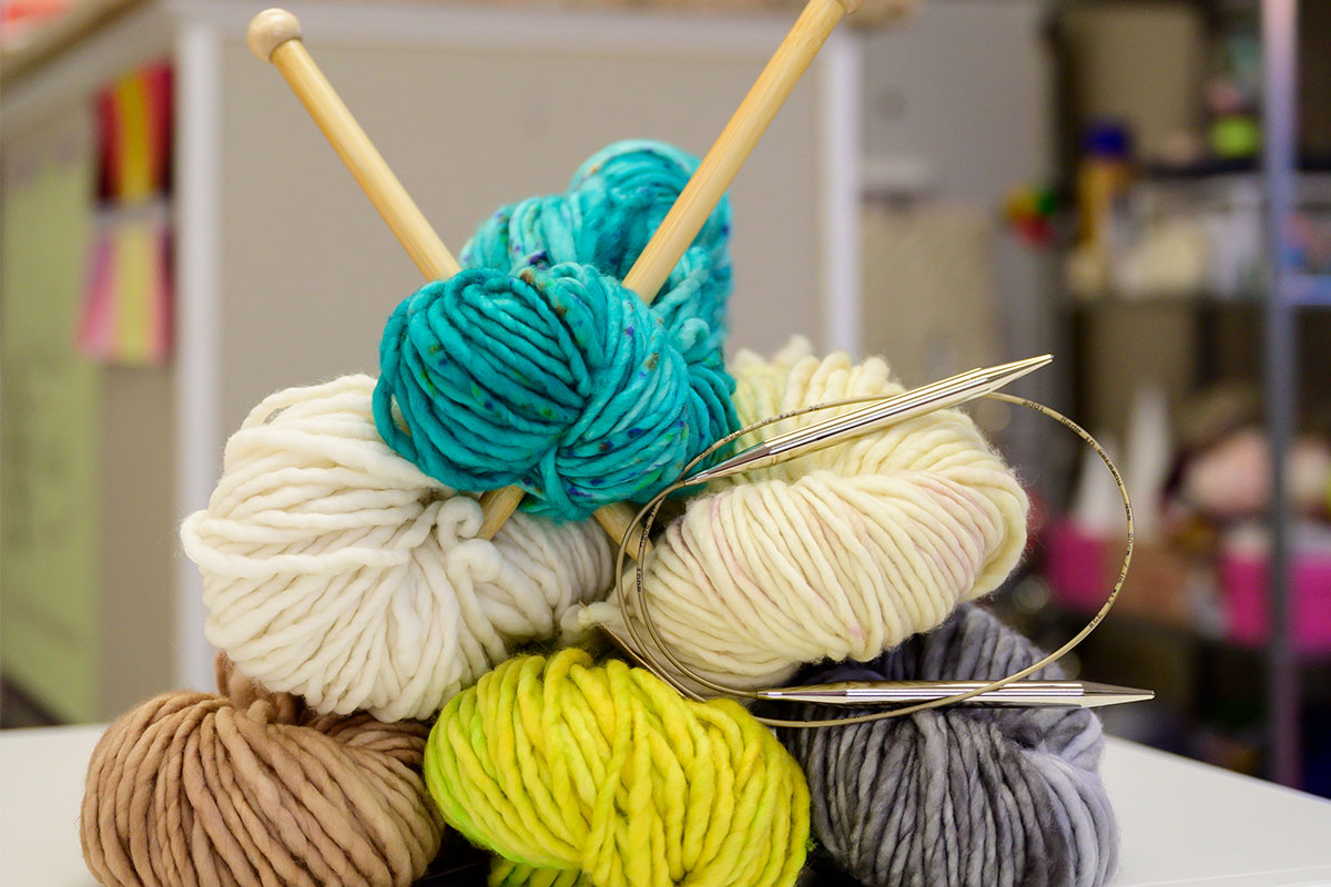 balls of yarn with knitting needles in them
