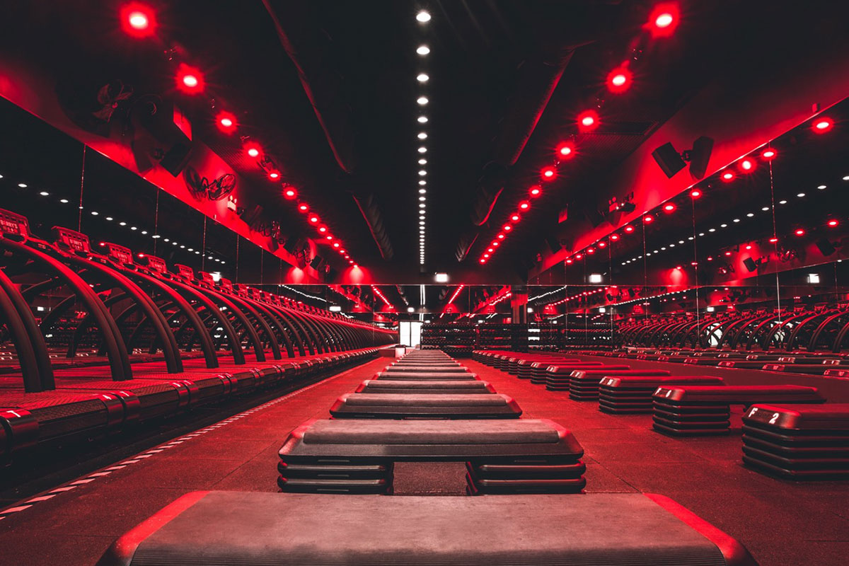 interior of barry's bootcamp in arlington virginia with red lighting treadmills and floor areas