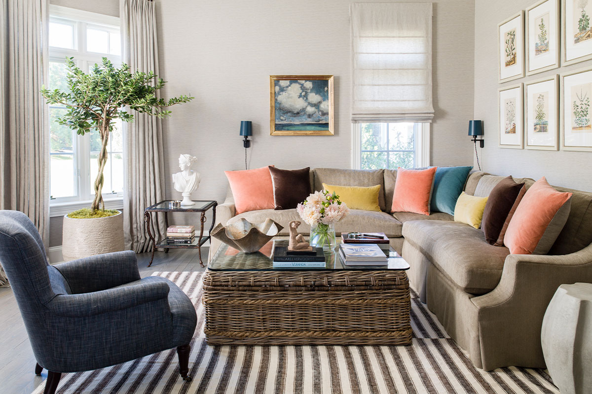living room with tan couch and light peach and yellow and blue pillows and chair