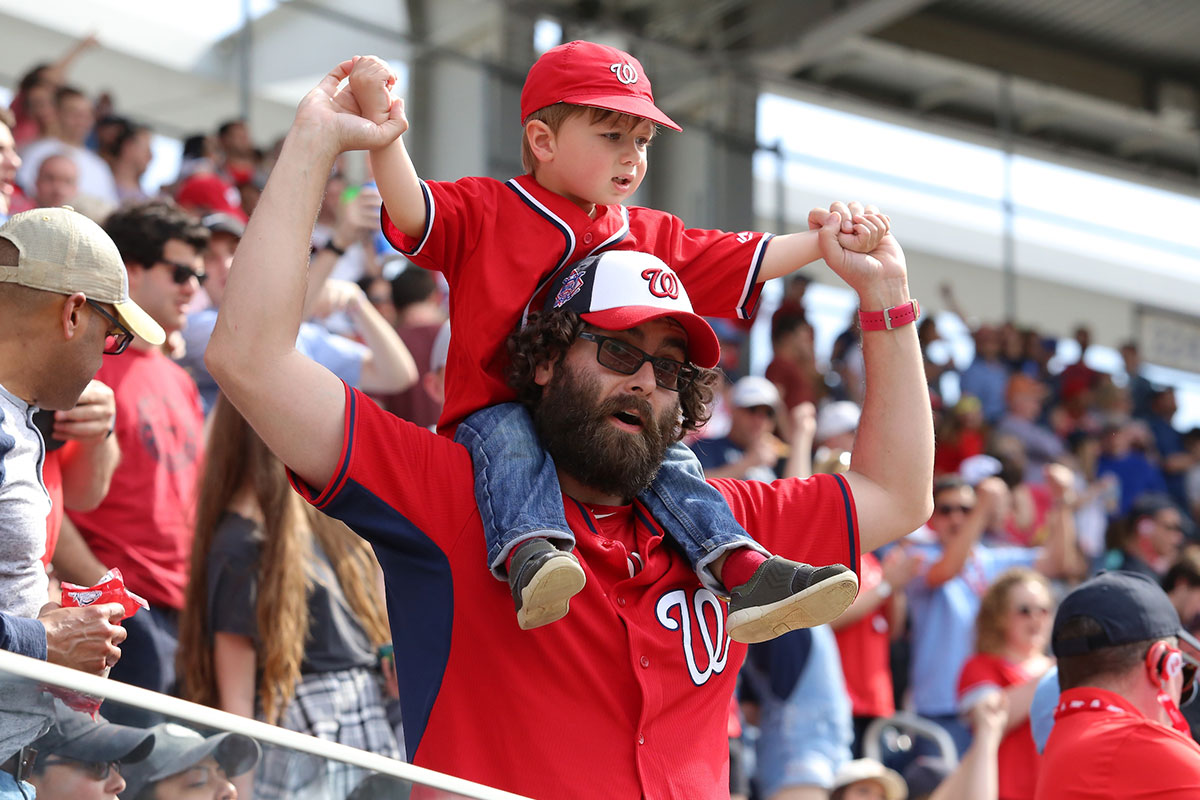 father at nats game with kid on his shoulders