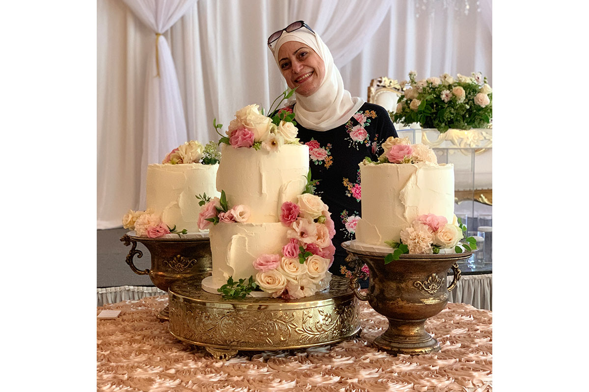 woman standing behind her cakes