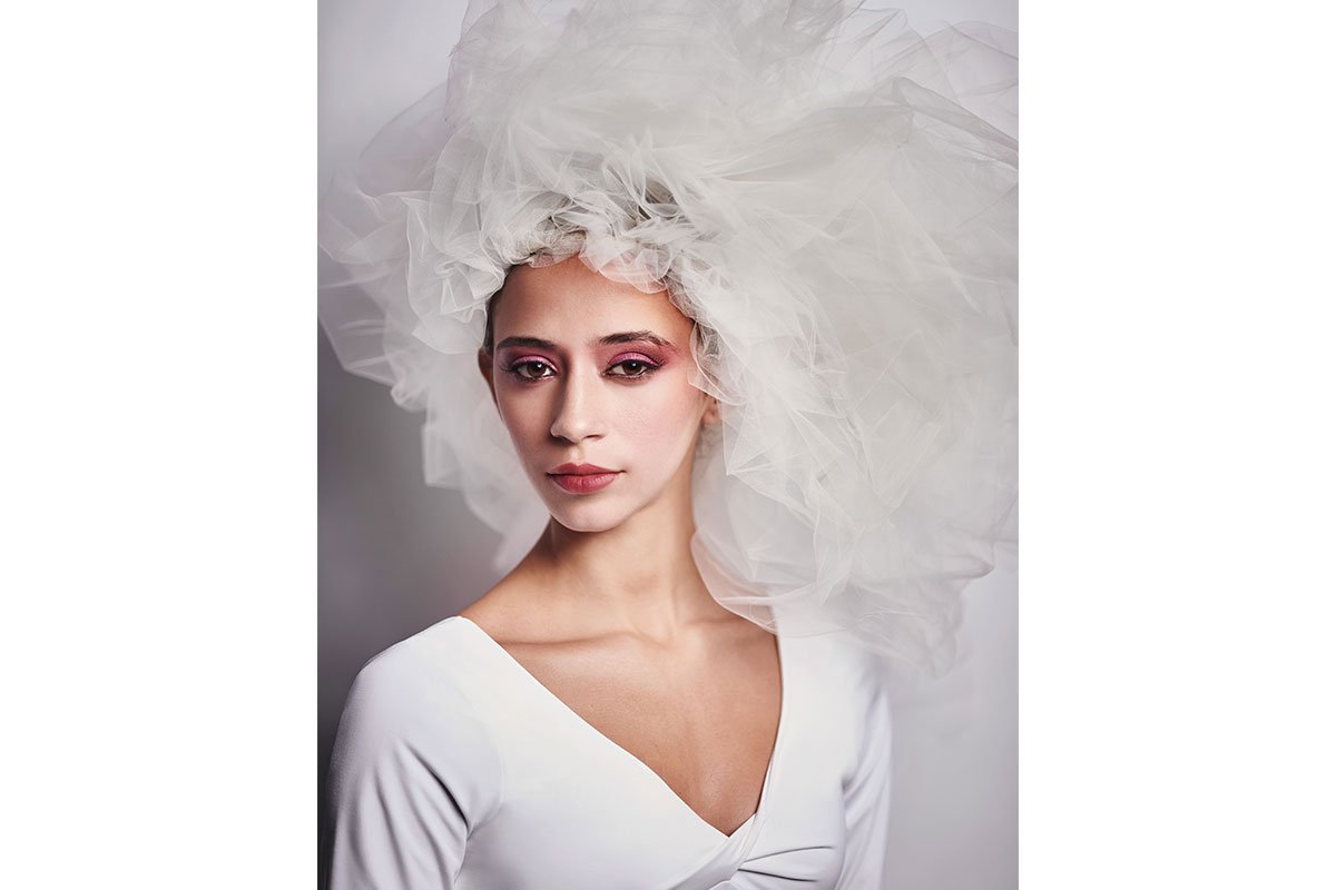 dancer with white puffy head dress on