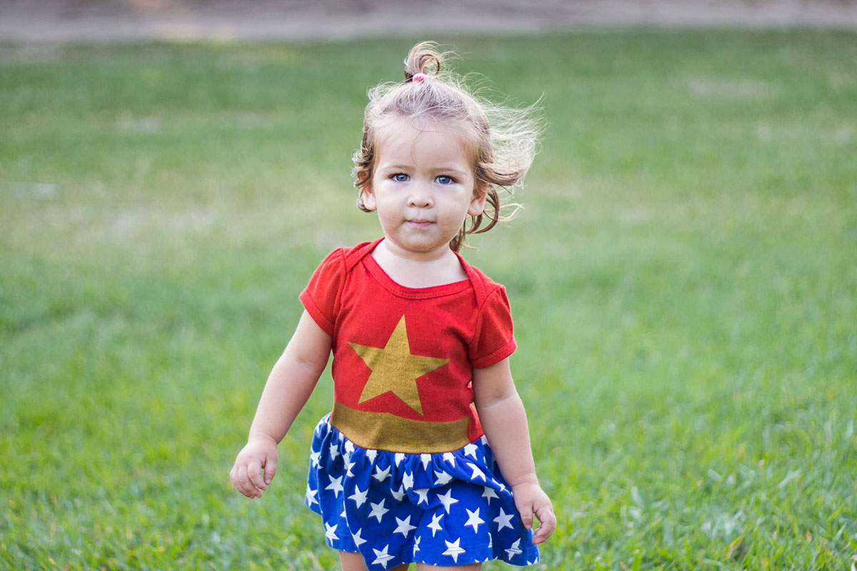 toddler girl in superwoman outfit
