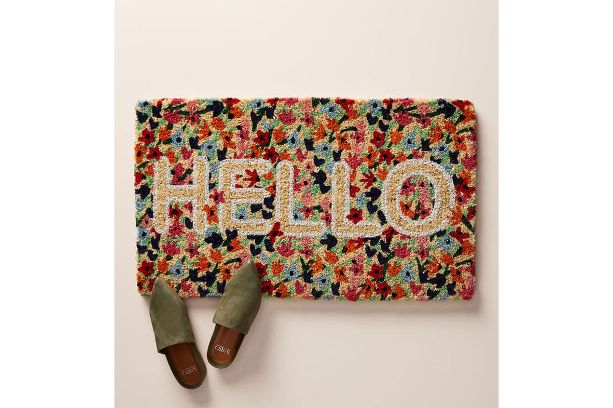 floral welcome mat with 'hello' and shoes on it