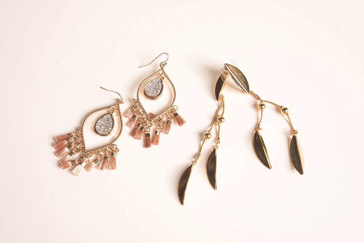 two pairs of earrings, one pink and one gold on white background