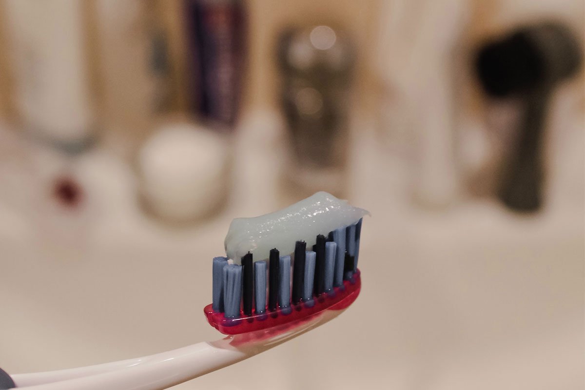 toothpaste on toothbrush with blue bristles