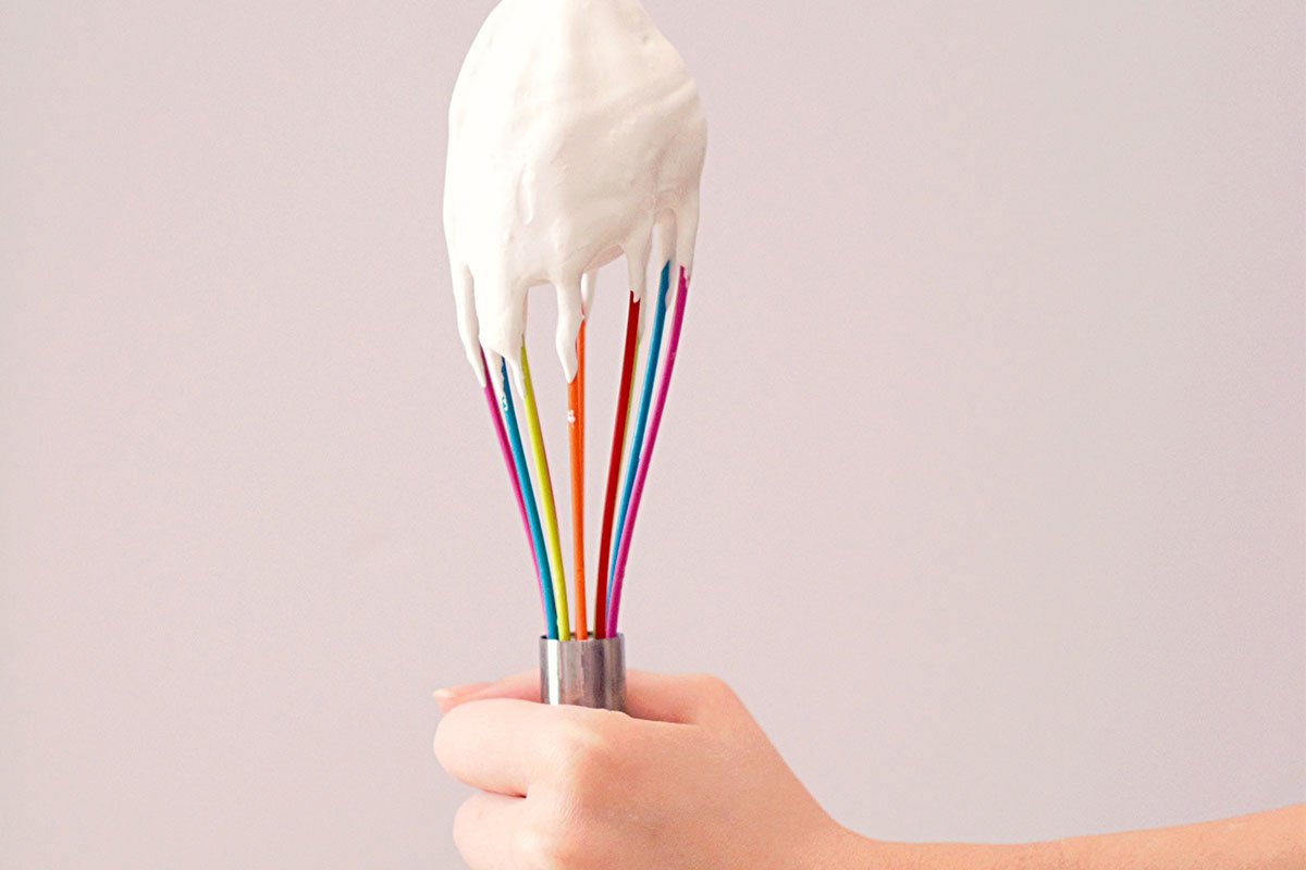 icing on a rainbow colored whisk