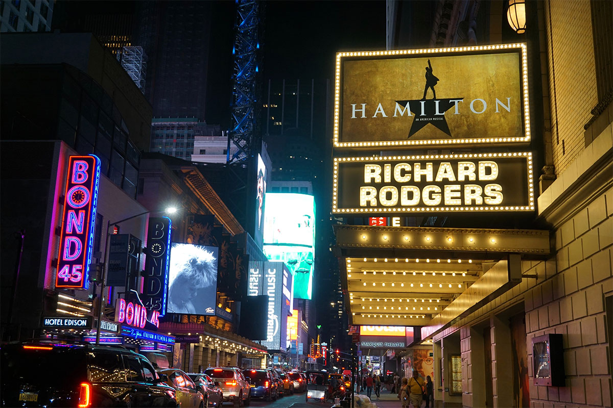 broadway in new york city showing a hamilton sign