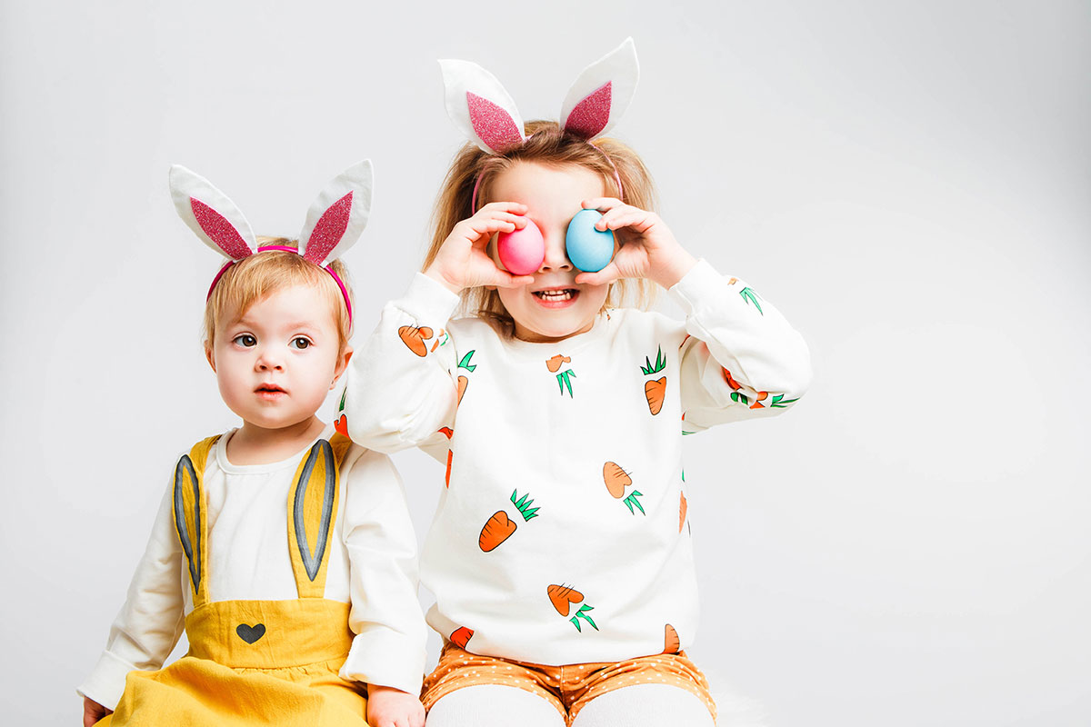 two children dressed up with easter bunny ears and eggs