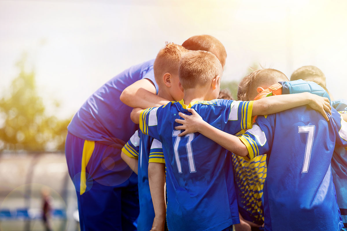 soccer team huddled up in blue jerseys