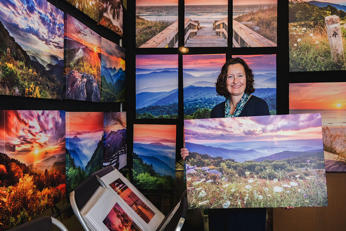 woman holding landscape photography at art festival