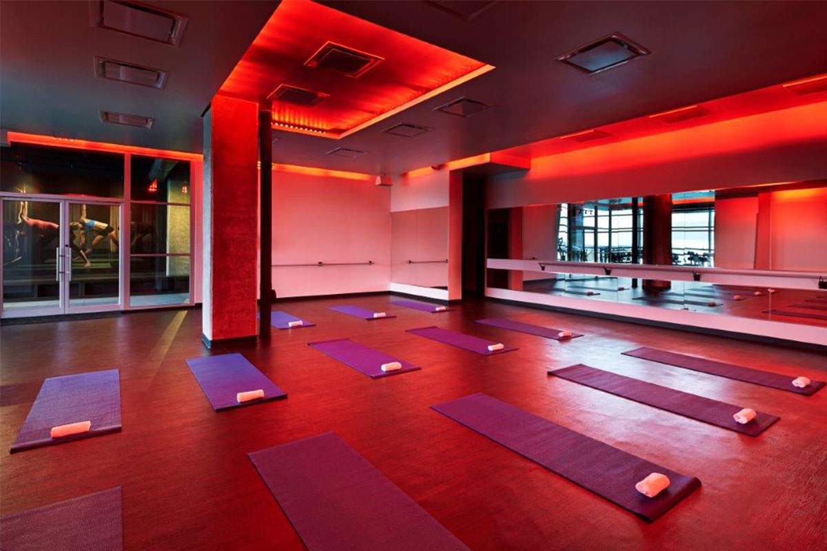 room with red lights and walls with yoga mats and towels vida fitness dc