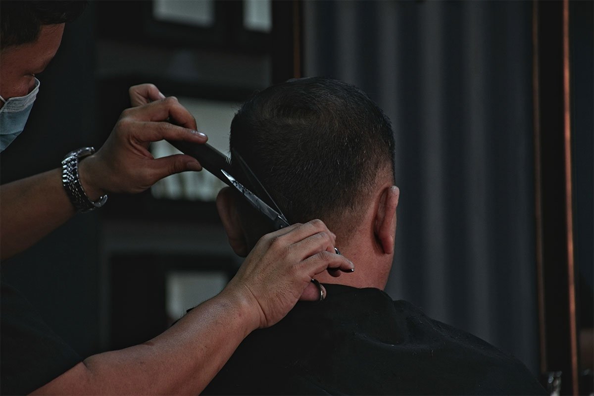 men's shaved haircut with scissors