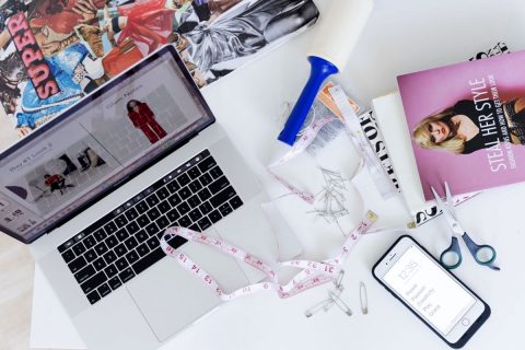 desk of a designer with magazines and computer